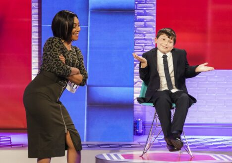 Tiffany Haddish laughs with a young guest while filming a television show.