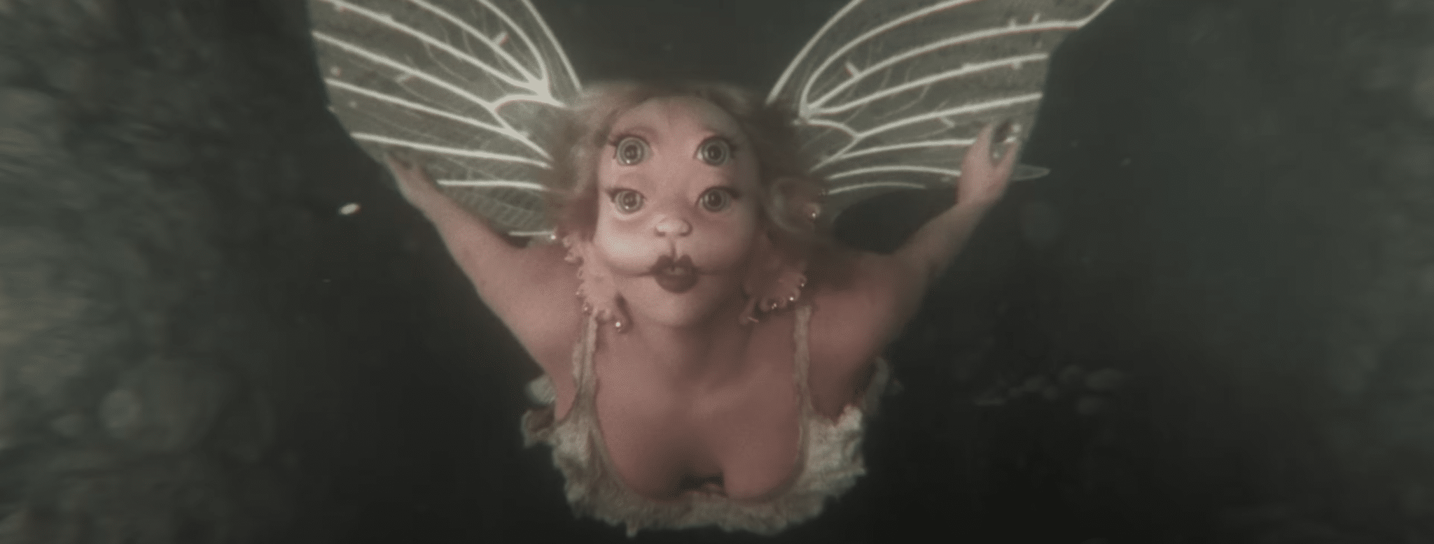 Melanie Martinez flying with fake wings.