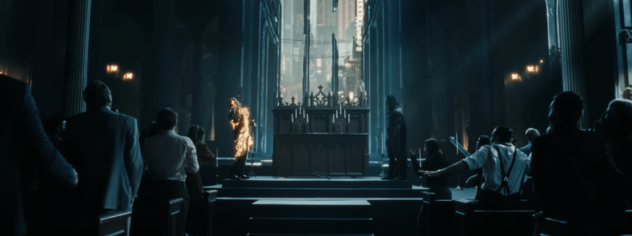 A priest is engulfed in flames inside a darkly lit church.